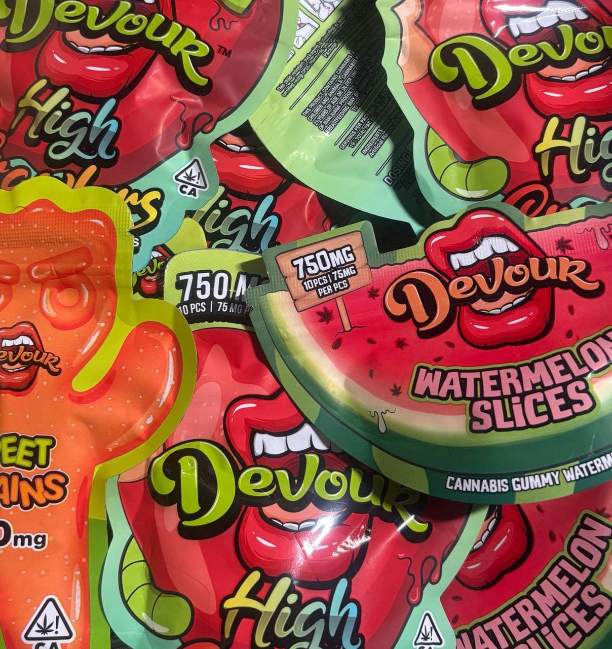 Vibrant Devour cannabis gummy pouches featuring red lips, watermelon slices, and 750mg dosage labels.