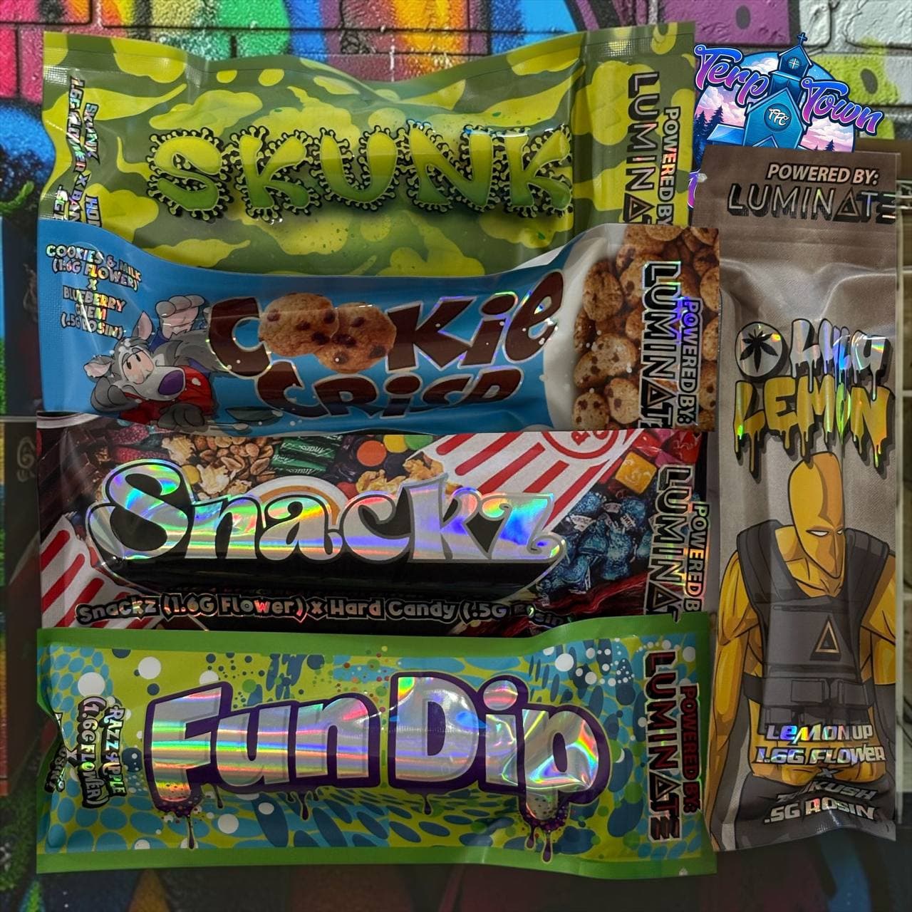 Stacked colorful cannabis product pouches with labels like Skunk, Cookie Crisp, and Fun Dip.