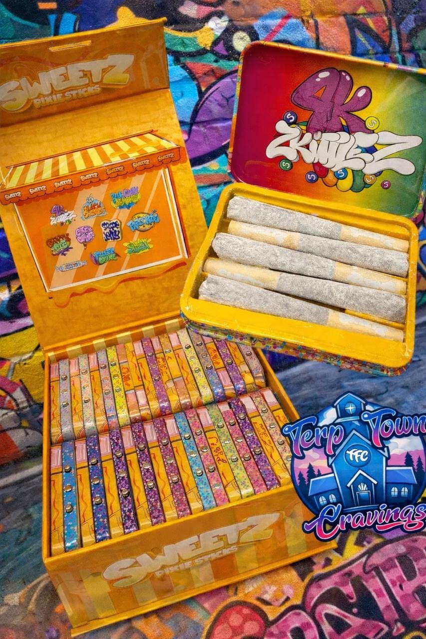 Sweetz and Zkittlez branded pre-rolled joints in yellow boxes against a vibrant graffiti wall.