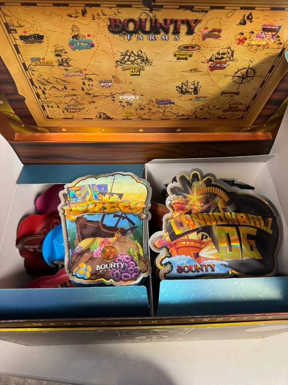 Pirate-themed Bounty Farms box with a map lid and colorful Shipwreck and Cannonball OG pouches.